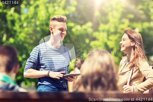 Image of group of teenage students with tablet pc outoors