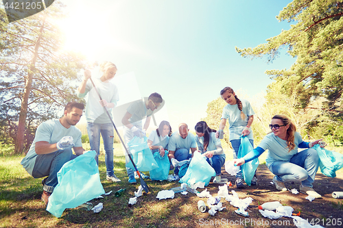 Image of volunteers with garbage bags cleaning park area