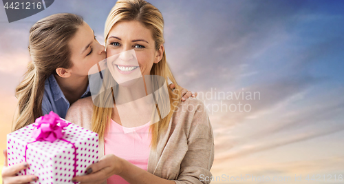 Image of daughter kissing mother and giving her present