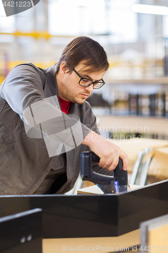 Image of assembler with screwdriver making furniture