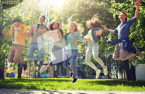 Image of happy teenage students or friends jumping outdoors