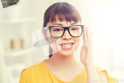 Image of happy asian young woman in glasses at home