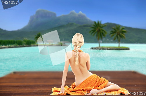 Image of bare woman with towel over bora bora background