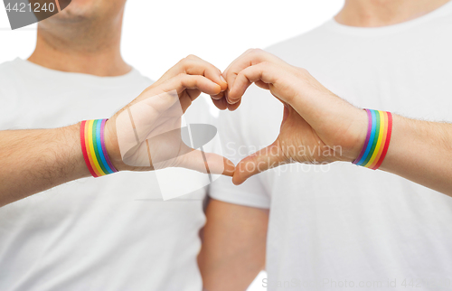 Image of gay couple with rainbow wristbands and hand heart