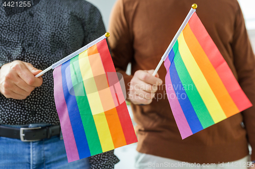 Image of close up of male couple with gay pride flags