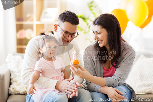 Image of baby girl with parents at home birthday party