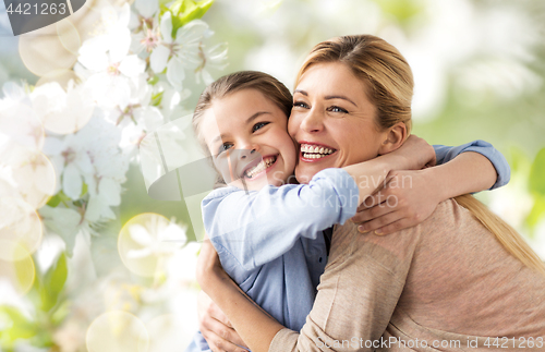 Image of happy mother hugging daughter over cherry blossom