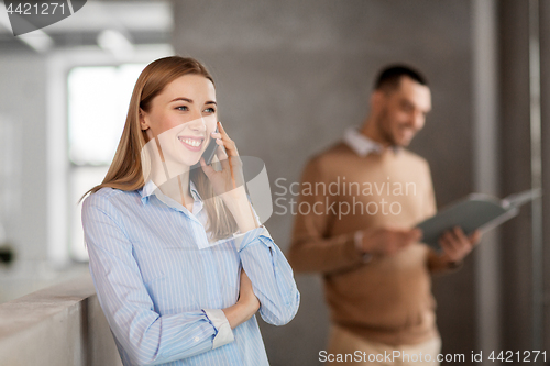 Image of businesswoman calling on smartphone at office