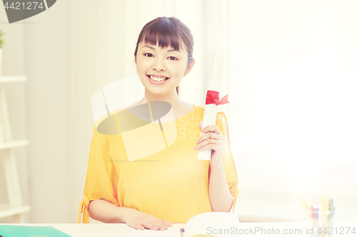 Image of happy asian woman student with diploma at home