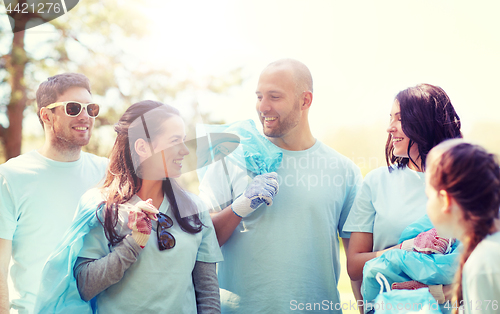 Image of volunteers with garbage bags walking outdoors