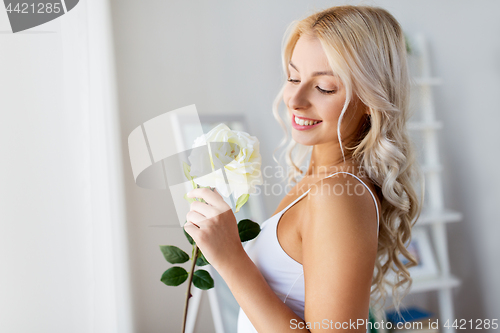 Image of woman in underwear with rose flower at window