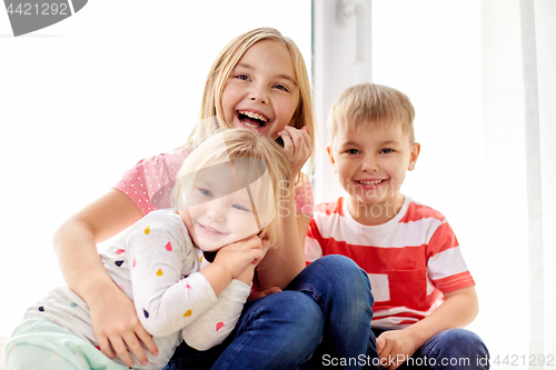 Image of happy little kids hugging at window