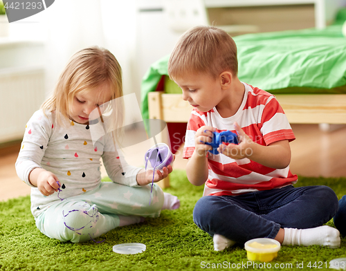 Image of little kids with modelling clay or slimes at home