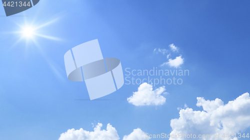 Image of bright blue sky with sun and clouds background