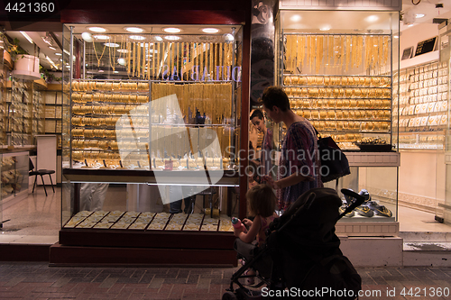 Image of mother with  little girl in a stroller in front of  jewelry shop
