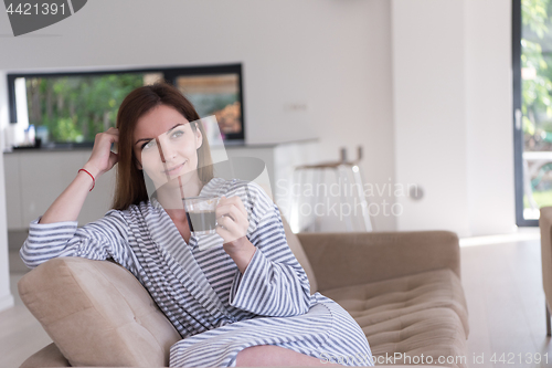 Image of young woman in a bathrobe enjoying morning coffee