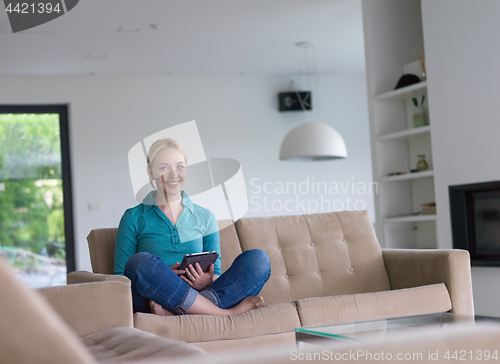 Image of woman on sofa using tablet computer