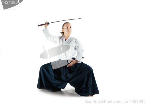 Image of Aikido master practices defense posture. Healthy lifestyle and sports concept. Woman in white kimono on white background.