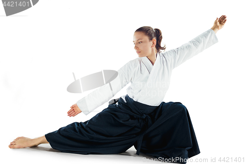 Image of Aikido master practices defense posture. Healthy lifestyle and sports concept. Woman in white kimono on white background.