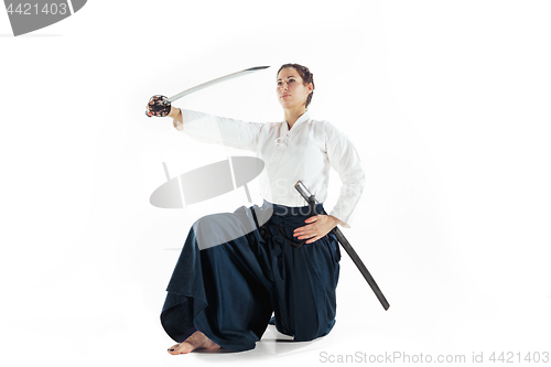 Image of Aikido master practices defense posture. Healthy lifestyle and sports concept. Woman in white kimono on white background.