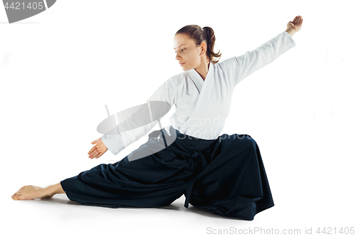 Image of Aikido master practices defense posture. Healthy lifestyle and sports concept. Woman in white kimono on white background.