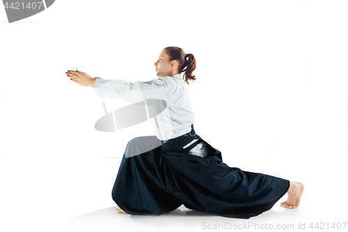 Image of Aikido master practices defense posture. Healthy lifestyle and sports concept. Woman in white kimono on white background.
