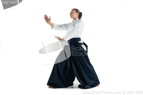 Image of Aikido master practices defense posture. Healthy lifestyle and sports concept. Woman in white kimono on white background.