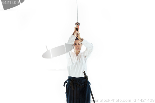 Image of Aikido master practices defense posture. Healthy lifestyle and sports concept. Woman in white kimono on white background.