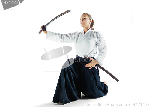 Image of Aikido master practices defense posture. Healthy lifestyle and sports concept. Woman in white kimono on white background.