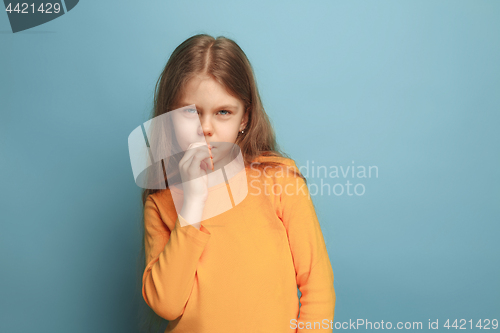 Image of The thoughtful girl. Teen girl on a blue background. Facial expressions and people emotions concept