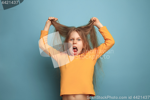 Image of The surprise. Teen girl on a blue background. Facial expressions and people emotions concept