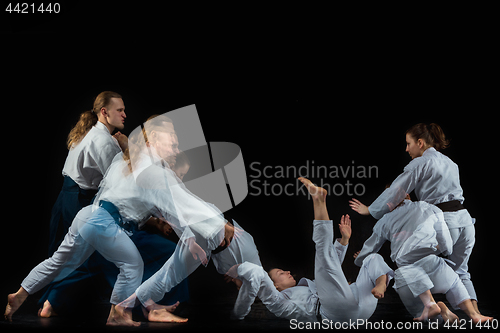 Image of Man and woman fighting at Aikido training in martial arts school