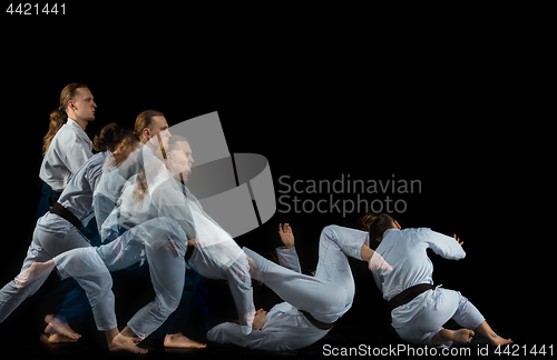 Image of Man and woman fighting at Aikido training in martial arts school