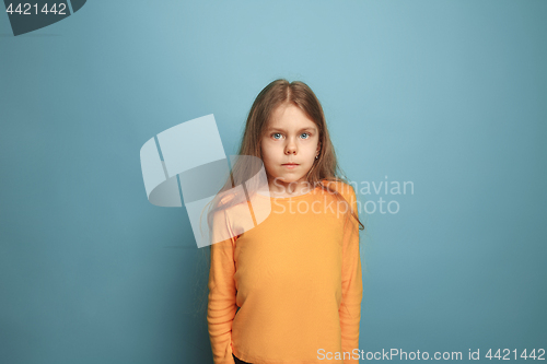 Image of The serious teen girl on a blue background. Facial expressions and people emotions concept