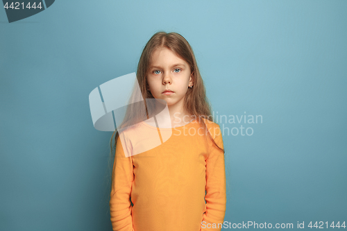 Image of The serious teen girl on a blue background. Facial expressions and people emotions concept