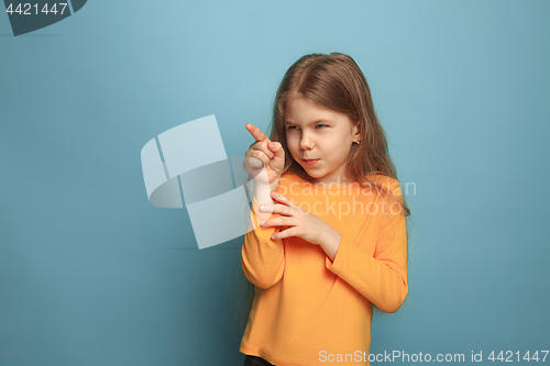 Image of The determination. Teen girl on a blue background. Facial expressions and people emotions concept