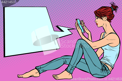 Image of Woman sitting on the floor and reading smartphone