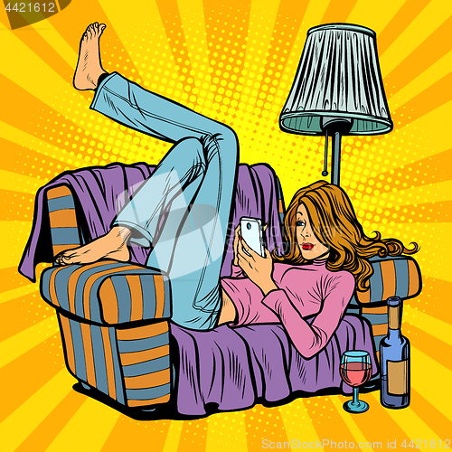 Image of Woman lying on the couch and reading smartphone