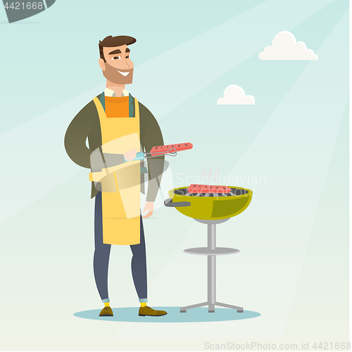 Image of Man cooking steak on barbecue grill.