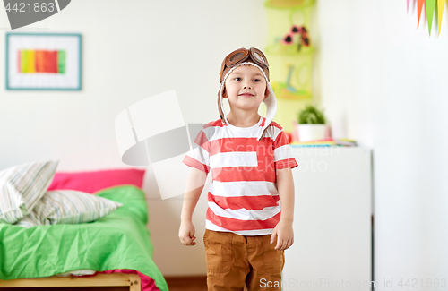 Image of happy little boy in pilot hat at home