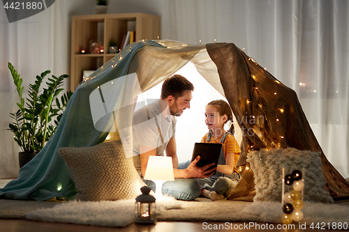 Image of family with tablet pc in kids tent at home