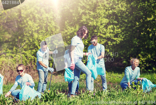 Image of volunteers with garbage bags cleaning park area