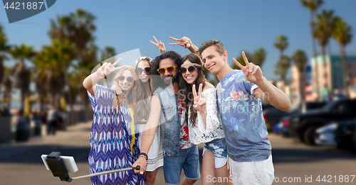 Image of hippie friends with smartphone on selfie stick