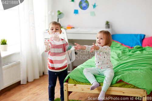 Image of kids blowing soap bubbles and playing at home