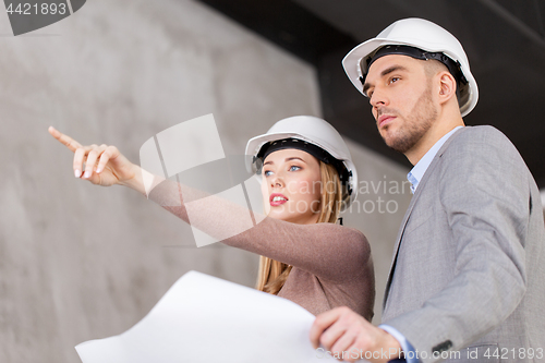 Image of architects in helmets with blueprint
