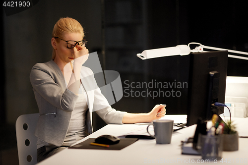 Image of tired businesswoman working at night office