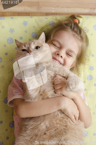 Image of The girl closed her eyes with joy, hugging her pet cat