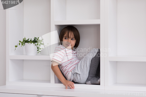 Image of young boy posing on a shelf