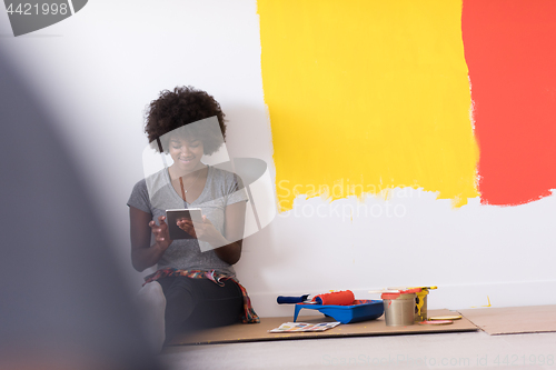 Image of back female painter sitting on floor