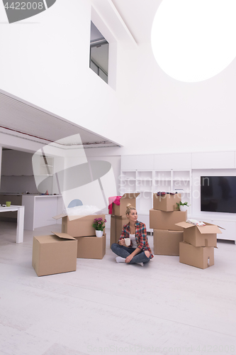 Image of woman with many cardboard boxes sitting on floor